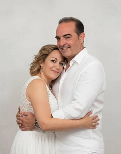 Cinthya y David vestidos de blanco, abrazados y sonriendo